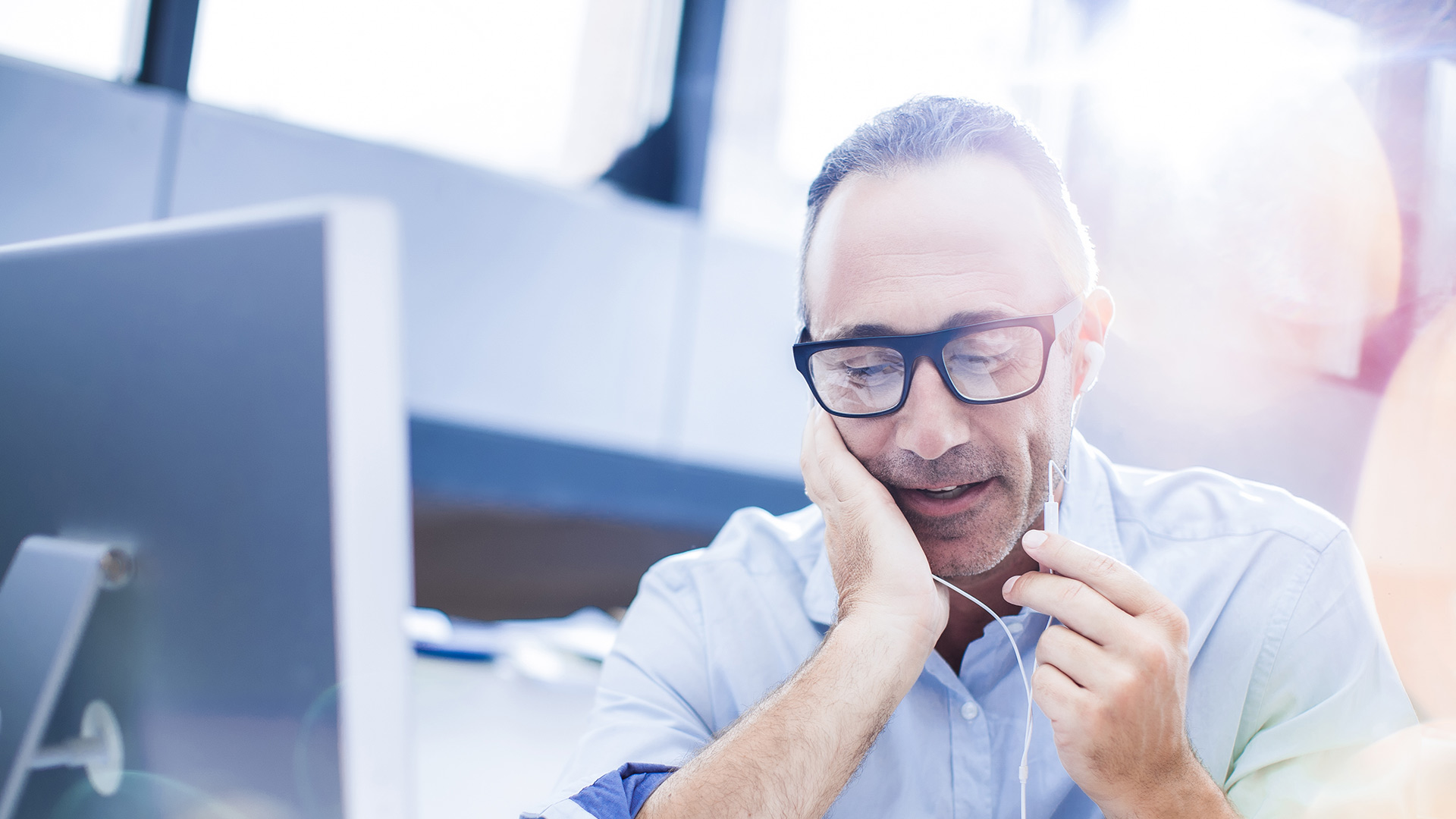 Datenschutzerklärung der Exportkreditgarantien des Bundes Ein Mann sitzt vor einem Bildschirm und spricht in sein Headset