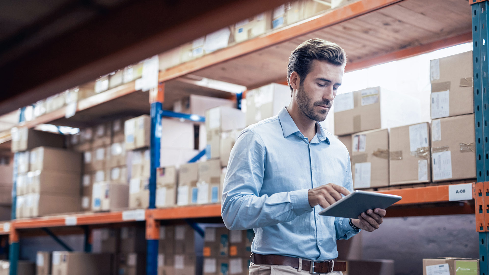 Employee walks through a warehouse with a tablet