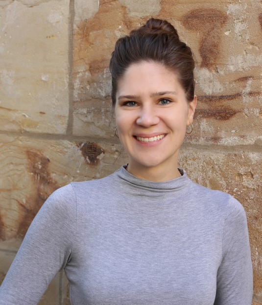 Bild: Frau im Vordergrund und Personen im Hintergrund an einem Stehtisch