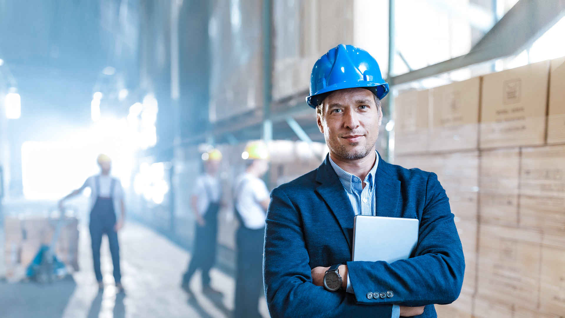 Image: An employee in a suit is standing in a warehouse