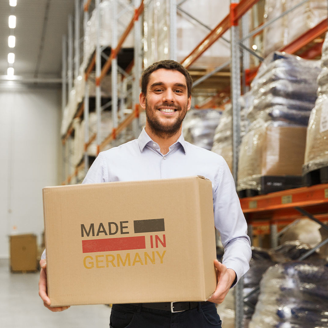 Employee standing in a warehouse with a "Made in Germany" box