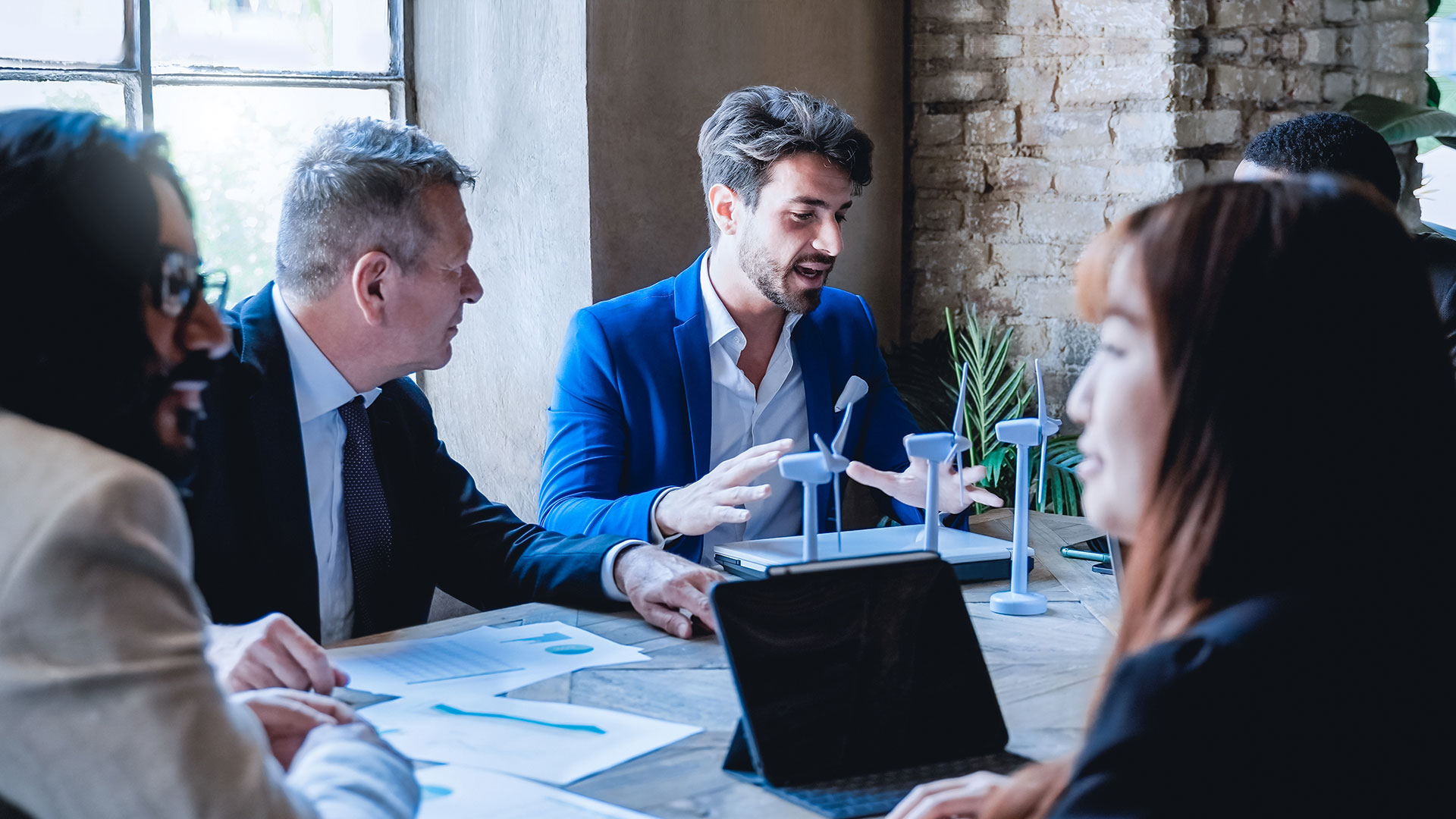 Mitarbeiter erklärt anhand eines Modells im Meeting eine Windkraftanlage