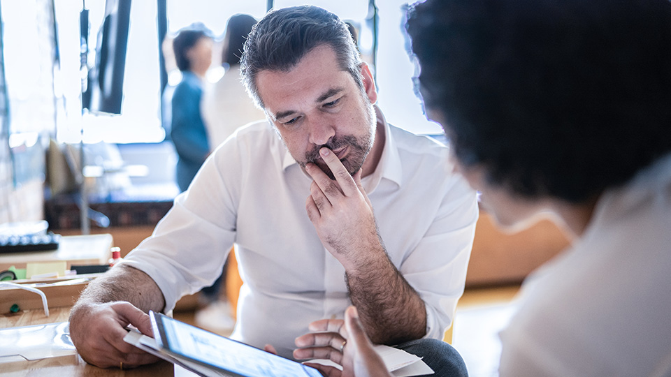 Mitarbeiter besprechen Inhalte auf einem Tablet