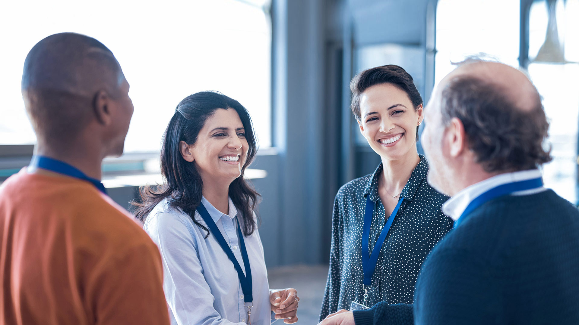 Four employees exchange ideas and smile