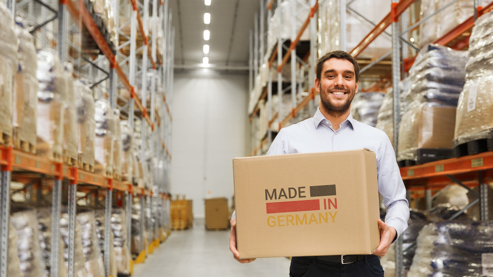 Employé debout dans un entrepôt avec une boîte « Made in Germany »