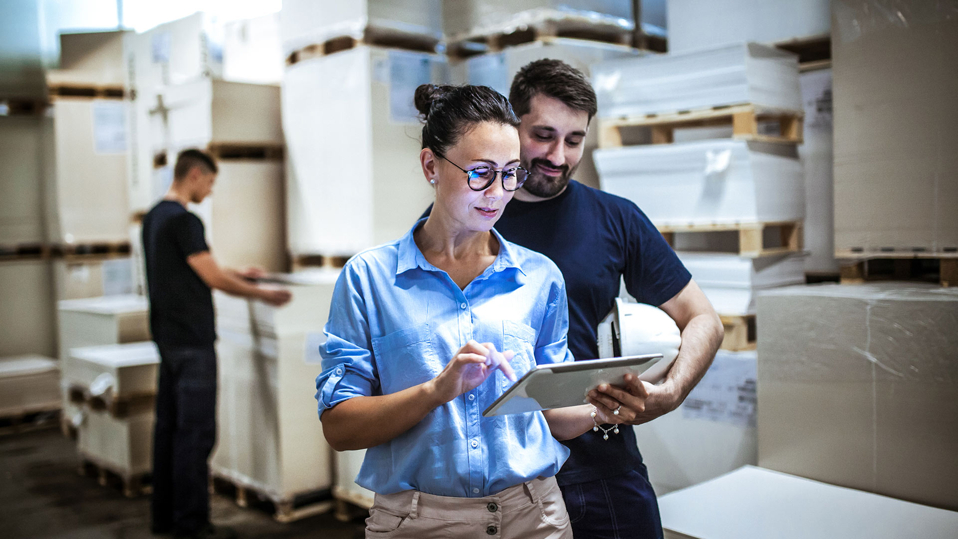 Employee showing something on a tablet to an employee in a warehouse