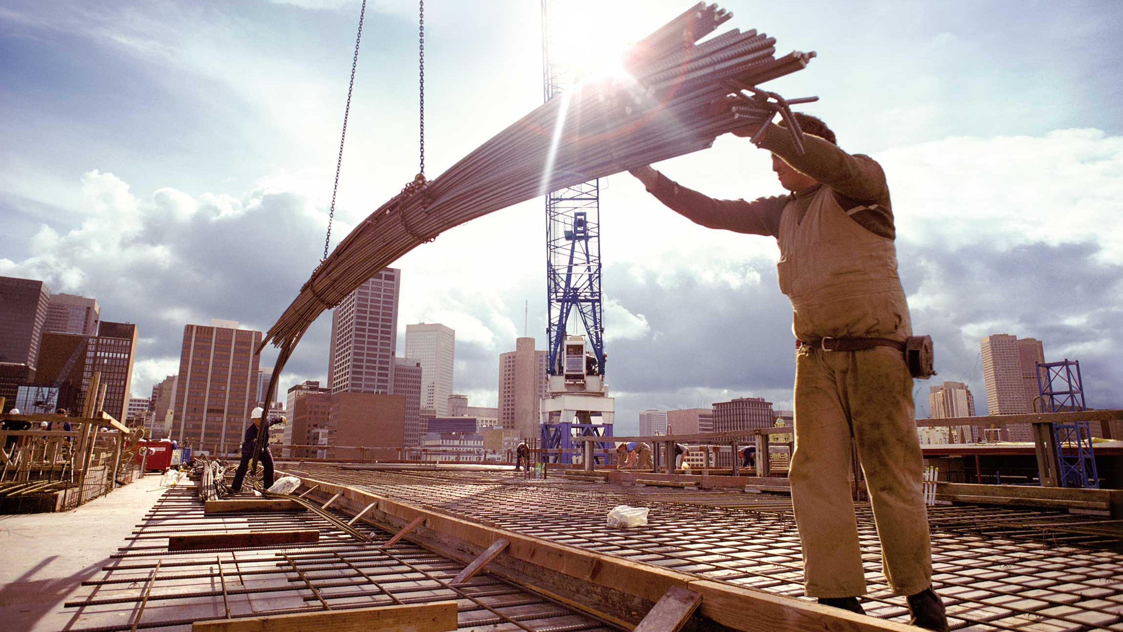 Bild: Auf einer Baustelle installieren Bauarbeiter Stahlträger