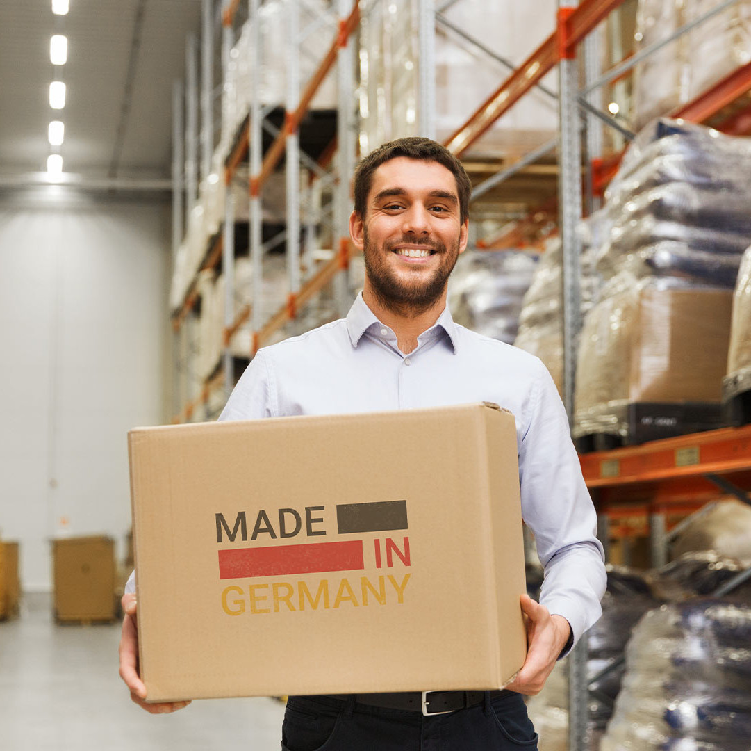 Employee standing in a warehouse with a "Made in Germany" box