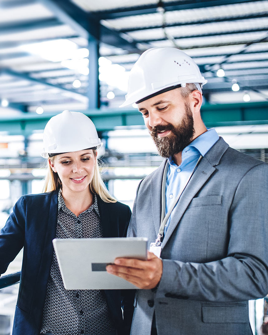 Title picture Export Credit Guarantees of the Federal Government | Two people in a workshop are looking at a tablet