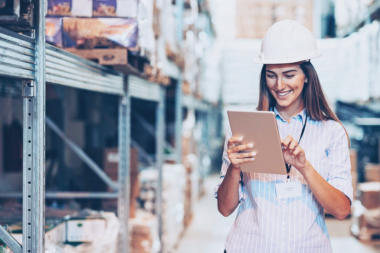 Export Insights - August 2026 Woman with a tablet in her hand in a high-bay warehouse